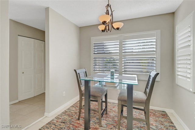 dining room featuring an inviting chandelier, light tile patterned floors, and baseboards