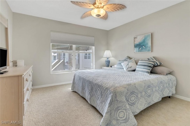 bedroom featuring baseboards, light colored carpet, and a ceiling fan