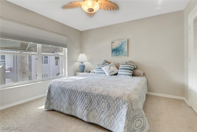 bedroom with a ceiling fan, baseboards, and carpet floors