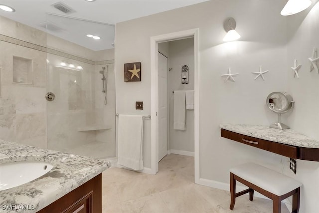 full bathroom with vanity, baseboards, visible vents, and walk in shower