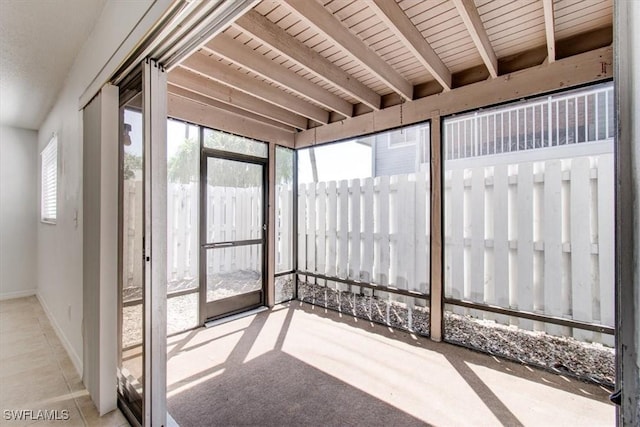 unfurnished sunroom with beamed ceiling