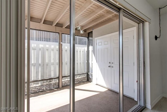 unfurnished sunroom featuring beamed ceiling