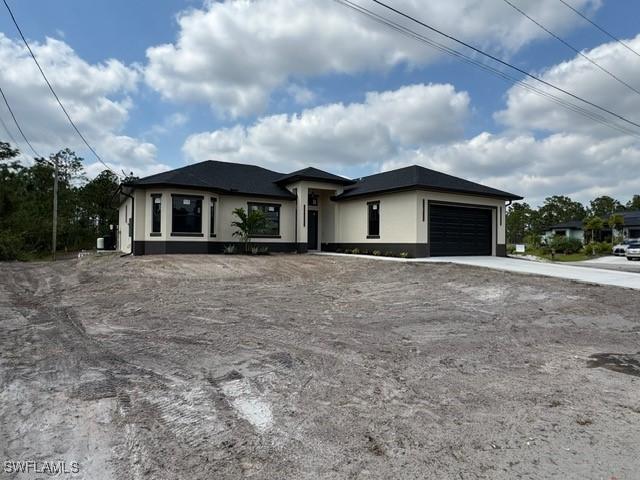 view of front of house featuring stucco siding, driveway, and a garage