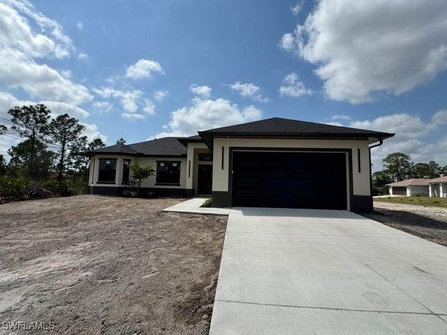 prairie-style home featuring concrete driveway and an attached garage