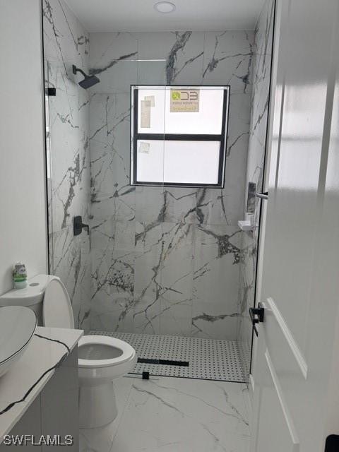 bathroom featuring a marble finish shower, marble finish floor, toilet, and vanity
