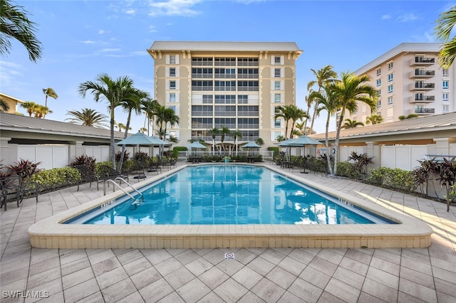 view of pool with a patio area and fence