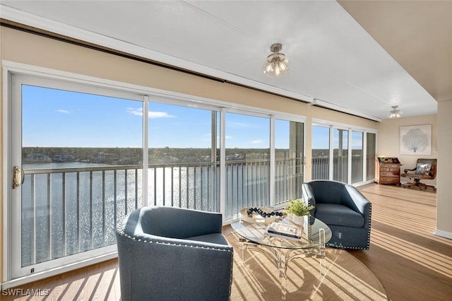 sunroom featuring a water view