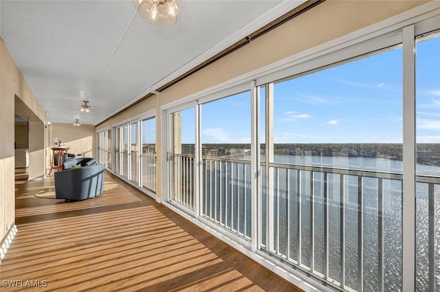 unfurnished sunroom featuring a water view