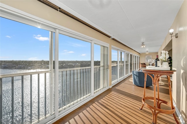 sunroom with a wealth of natural light and a water view