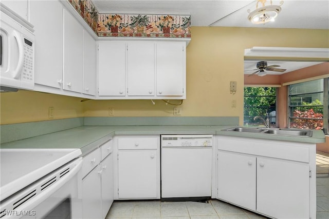 kitchen with white appliances, white cabinets, light countertops, and a sink