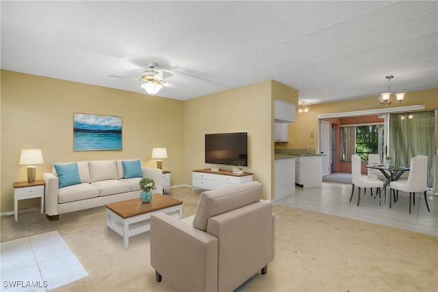 living area featuring light carpet, a textured ceiling, and ceiling fan with notable chandelier