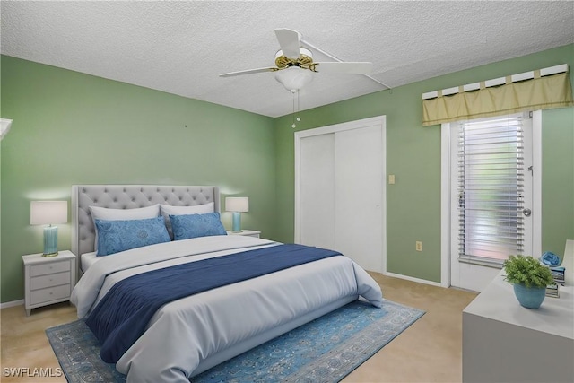 bedroom featuring a closet, baseboards, a textured ceiling, and ceiling fan