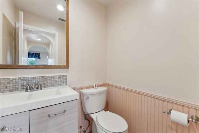 bathroom with visible vents, wainscoting, toilet, and vanity