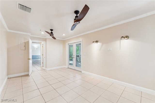 spare room with light tile patterned floors, visible vents, crown molding, and baseboards