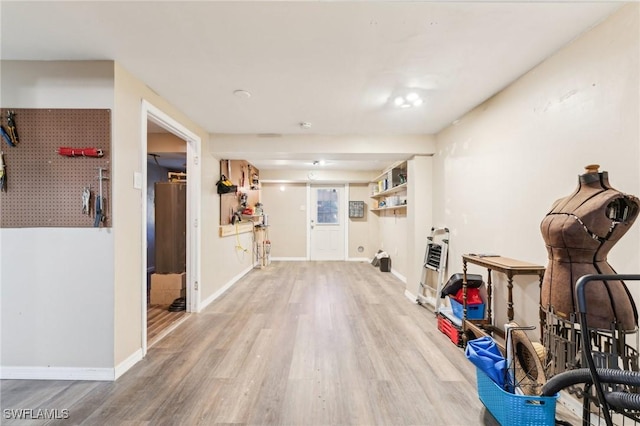 workout area featuring baseboards and wood finished floors