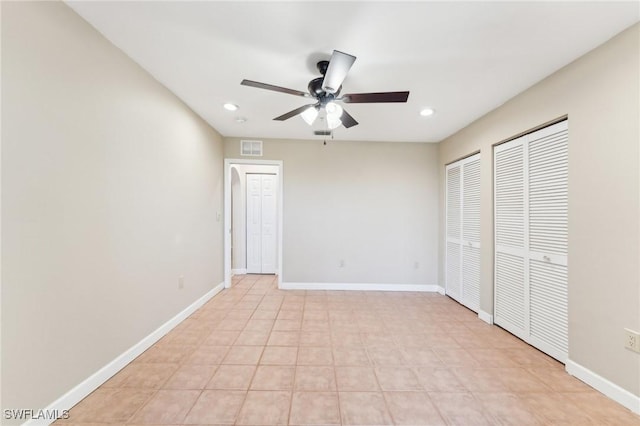 unfurnished bedroom with recessed lighting, baseboards, and two closets