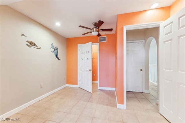 unfurnished bedroom with visible vents, baseboards, recessed lighting, arched walkways, and a ceiling fan