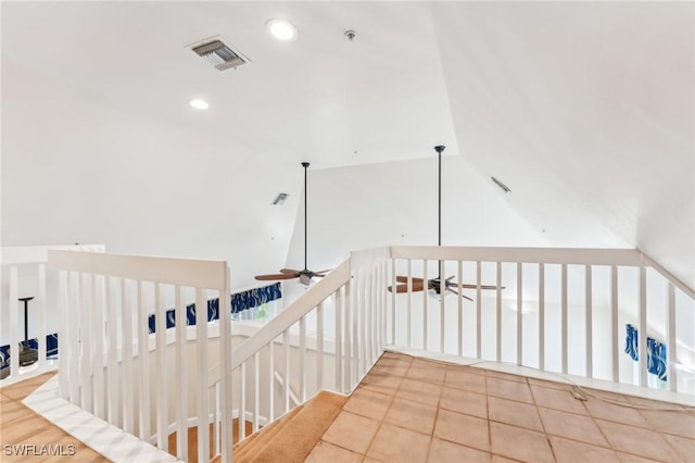 hallway with tile patterned flooring, visible vents, recessed lighting, and vaulted ceiling