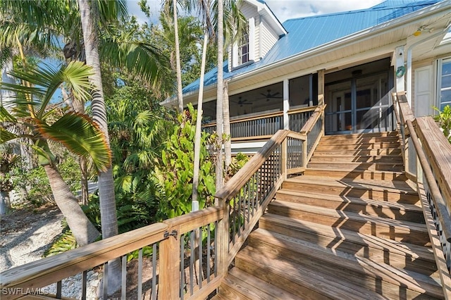 wooden deck with stairs, a ceiling fan, and a sunroom