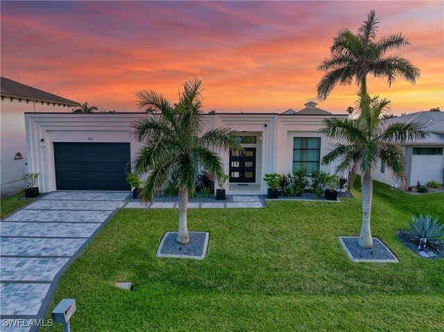 836 Miramar Ct, Cape Coral, FL 33904 - view of front of home featuring a lawn, decorative driveway, a garage, and stucco siding