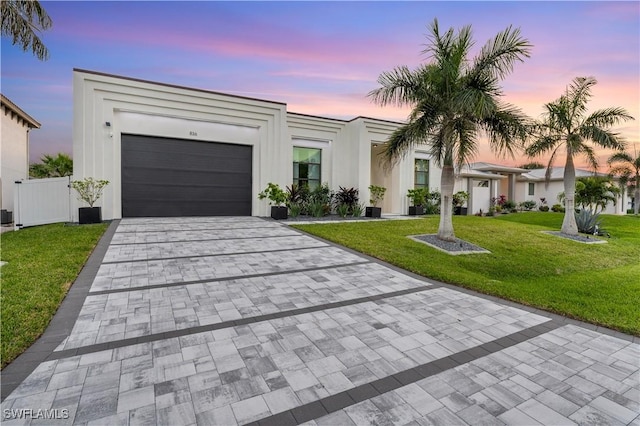 836 Miramar Ct, Cape Coral, FL 33904 - view of front of property featuring a front lawn, fence, stucco siding, decorative driveway, and an attached garage