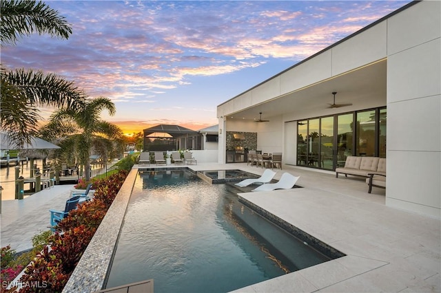 836 Miramar Ct, Cape Coral, FL 33904 - pool at dusk with a patio, ceiling fan, and a pool with connected hot tub