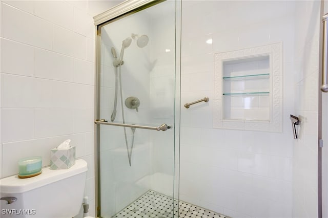 full bath featuring a shower stall, toilet, and tile walls