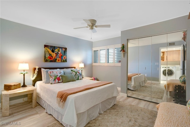 bedroom featuring a ceiling fan, visible vents, light wood finished floors, washing machine and clothes dryer, and a closet