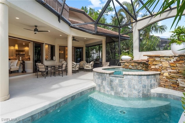 outdoor pool featuring glass enclosure, a patio, outdoor dining area, an outdoor hot tub, and a ceiling fan