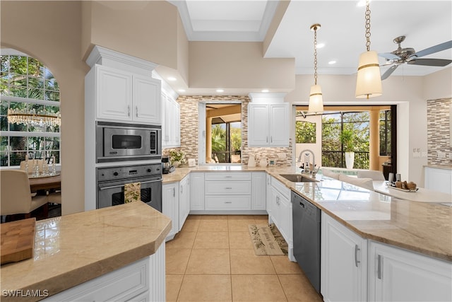 kitchen featuring a sink, tasteful backsplash, stainless steel appliances, light stone countertops, and ceiling fan