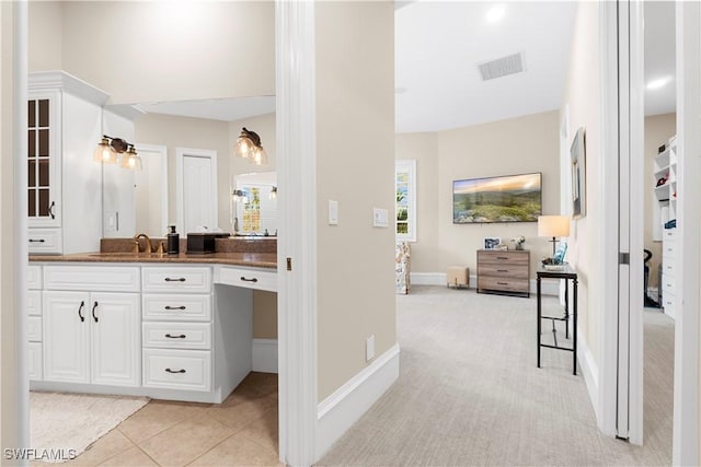 bathroom featuring tile patterned flooring, visible vents, vanity, and baseboards