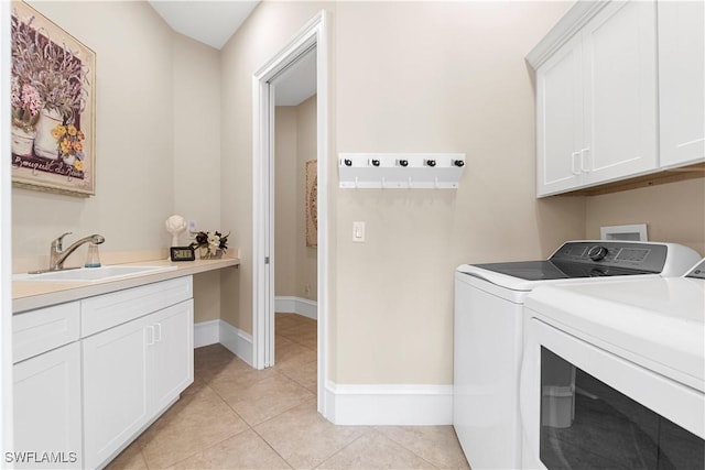 laundry area featuring light tile patterned flooring, cabinet space, independent washer and dryer, and a sink