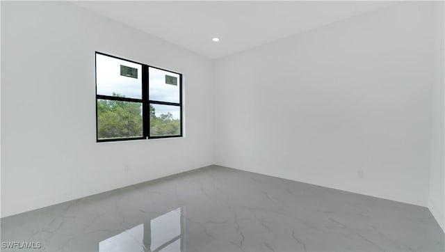 spare room featuring recessed lighting and marble finish floor