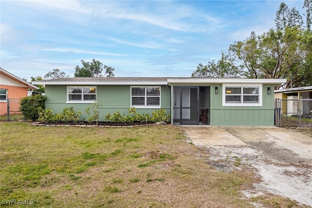 ranch-style home featuring driveway, a front yard, and fence