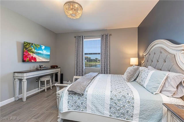 bedroom with wood finished floors and baseboards