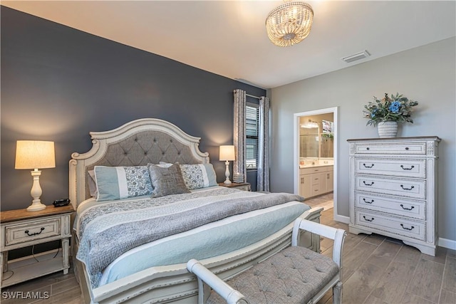 bedroom with visible vents, a notable chandelier, connected bathroom, baseboards, and wood tiled floor