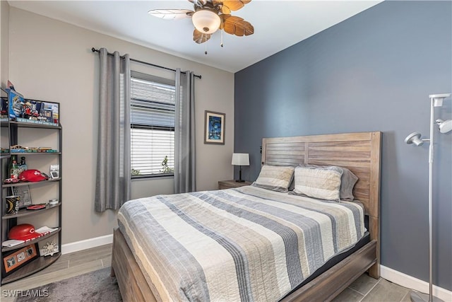 bedroom with a ceiling fan, wood finished floors, and baseboards