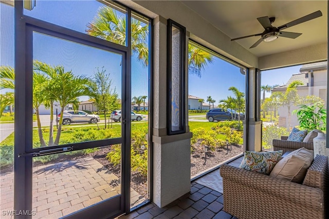 sunroom / solarium featuring a ceiling fan