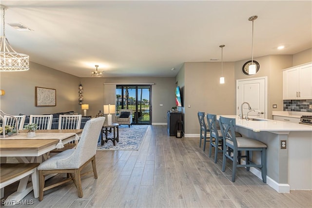 dining area featuring visible vents, baseboards, and light wood-style floors