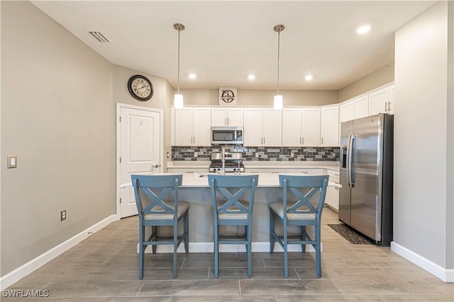 kitchen featuring white cabinets, backsplash, visible vents, and appliances with stainless steel finishes