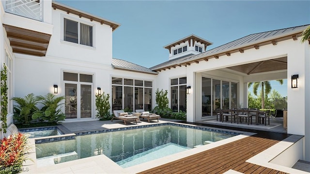 back of property featuring stucco siding, a pool with connected hot tub, a standing seam roof, a patio, and metal roof