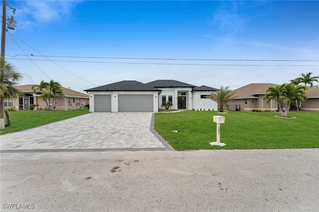 view of front of house with a front yard, decorative driveway, an attached garage, and stucco siding