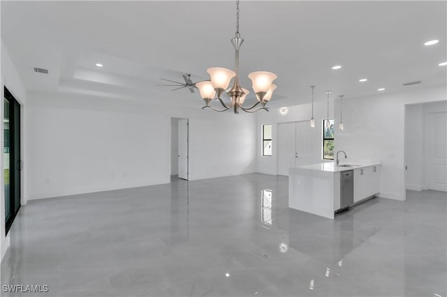 interior space with a sink, stainless steel dishwasher, open floor plan, and white cabinetry