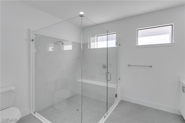 full bathroom featuring baseboards, toilet, and a shower stall