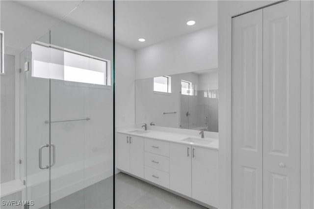 bathroom featuring double vanity, recessed lighting, a stall shower, and a sink