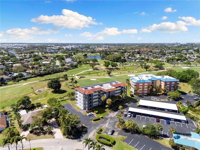 aerial view with golf course view and a water view