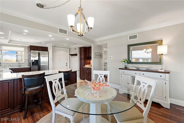 dining space with visible vents, a notable chandelier, dark wood-style floors, and crown molding