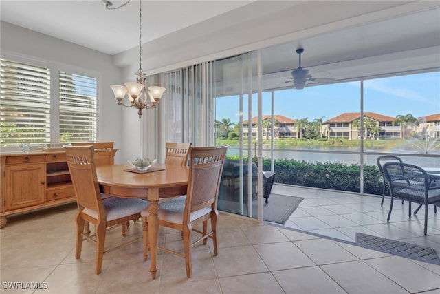 dining area with a water view, a residential view, light tile patterned floors, and ceiling fan with notable chandelier