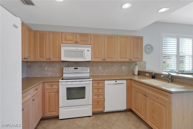 kitchen featuring white appliances, a peninsula, light brown cabinetry, and visible vents