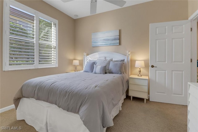carpeted bedroom featuring baseboards and a ceiling fan